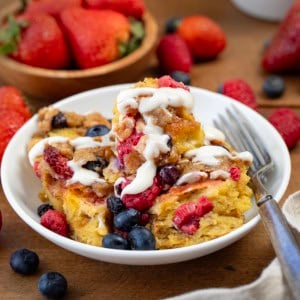 Bowl of Berries and Cream Overnight French Toast Bake on a wooden table close up.