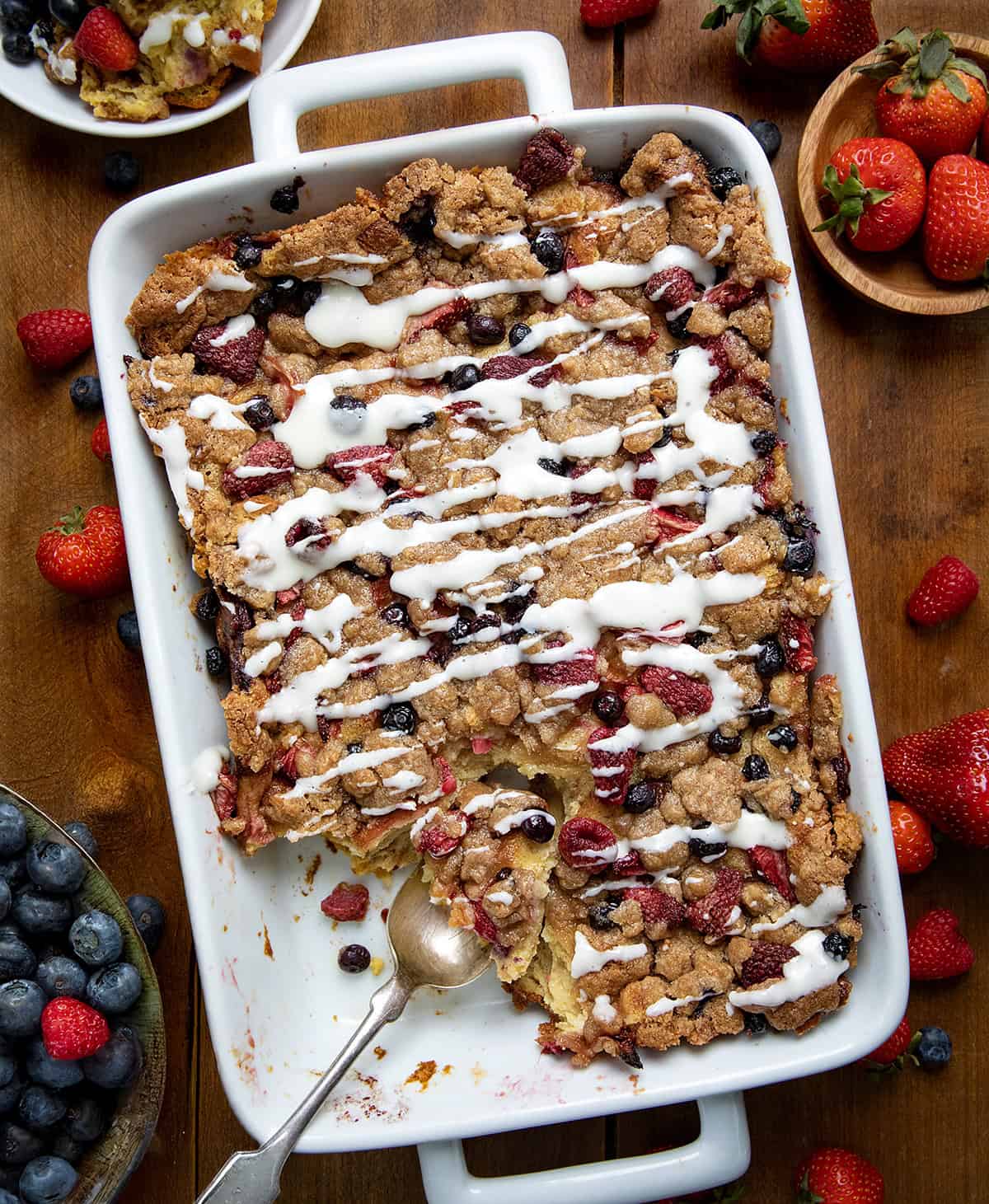 Berries and Cream Overnight French Toast Bake in a white pan on a wooden table from overhead.