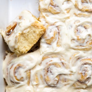 Close up of Biscuit Cinnamon Rolls in a pan with one roll on its side.