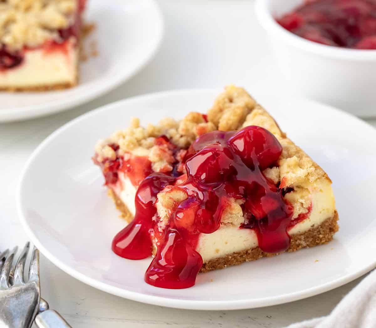 One Cherry Almond Cheesecake Bar on a white plate close up.