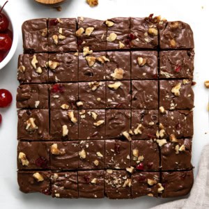 Cherry Fantasy Fudge cut into small pieces on a white counter top.