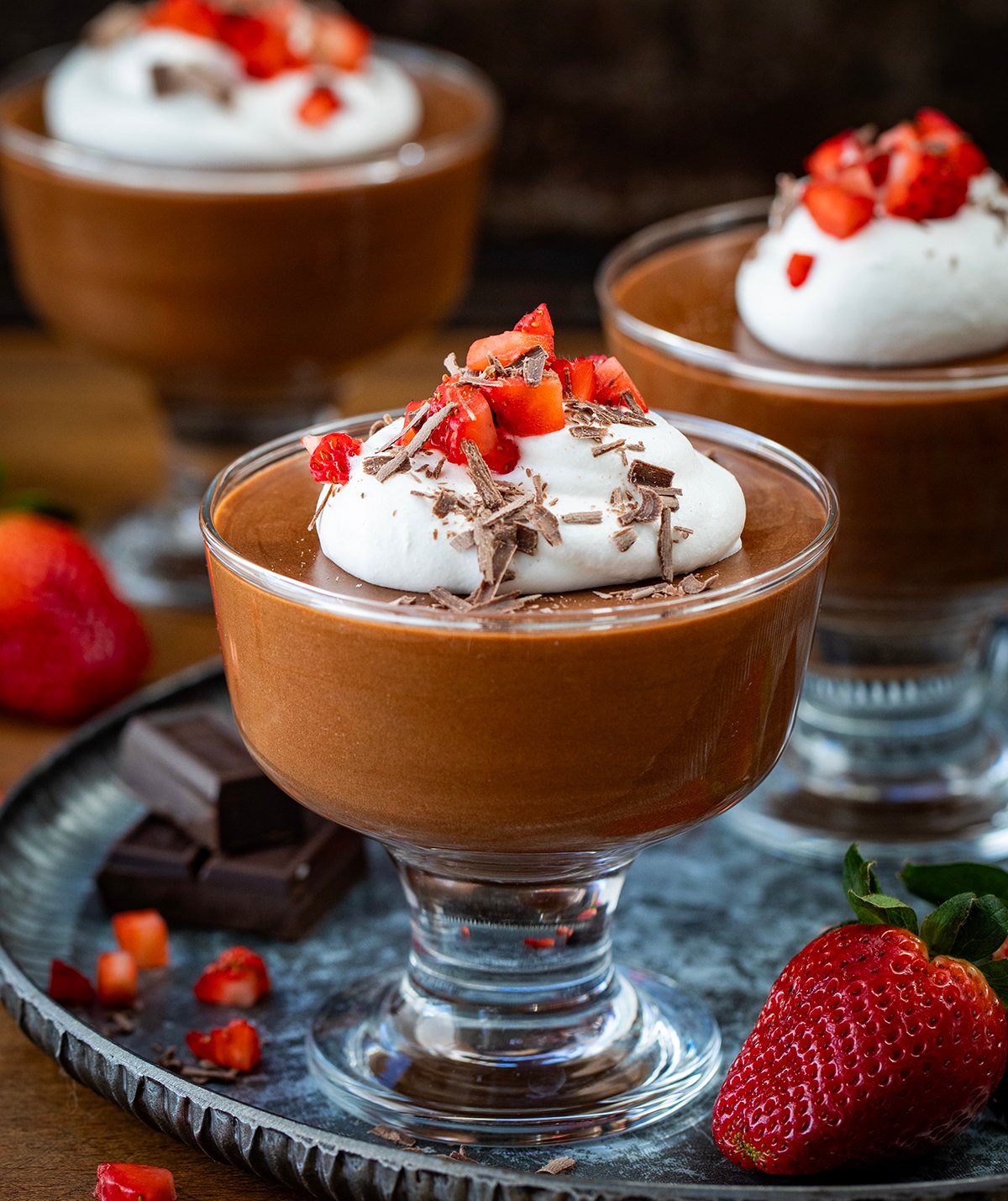 Cups of Chocolate Marshmallow Mousse with whipped cream and strawberries. 