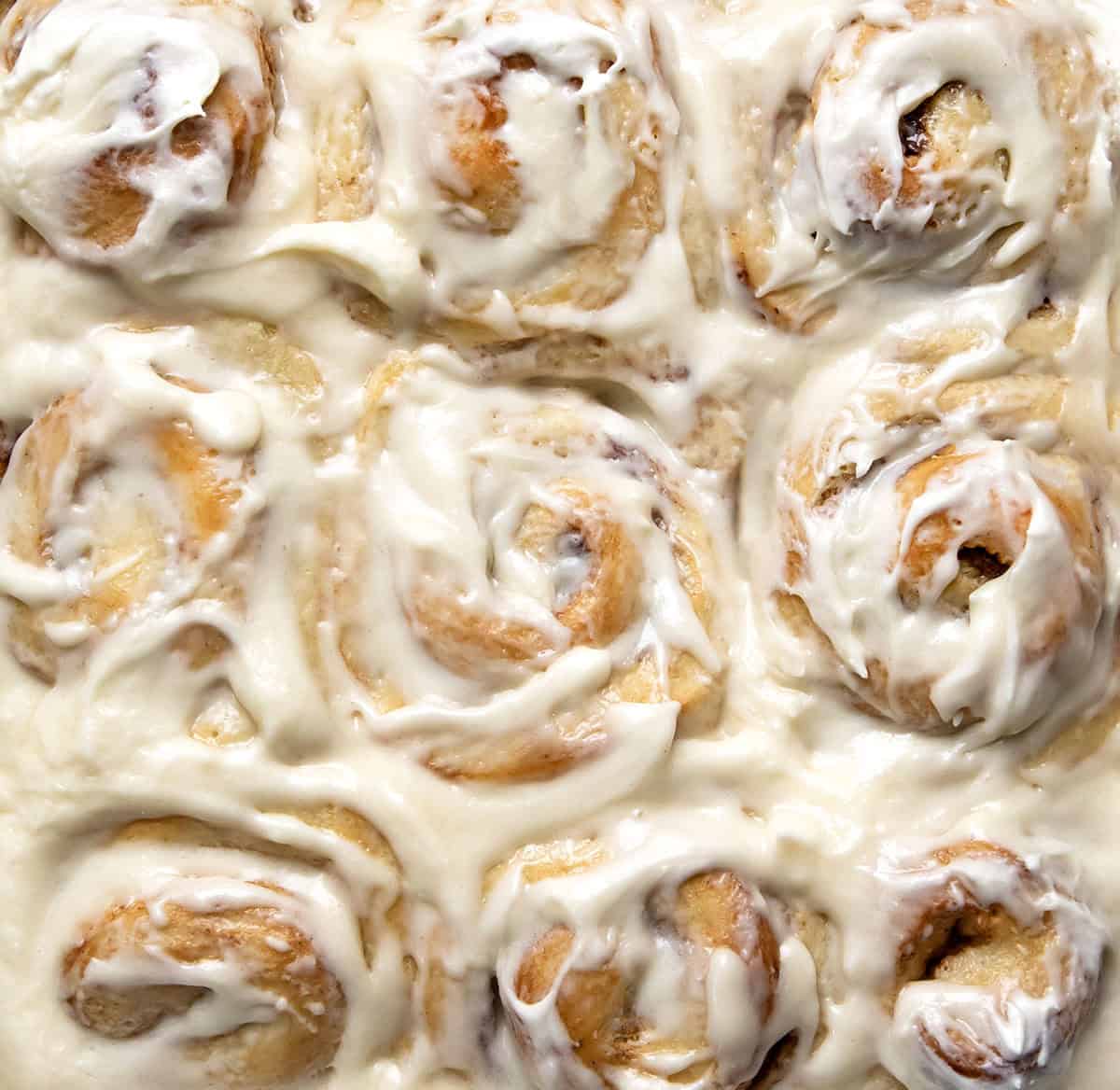 Close up of frosting covered One Hour Cinnamon Rolls from overhead.