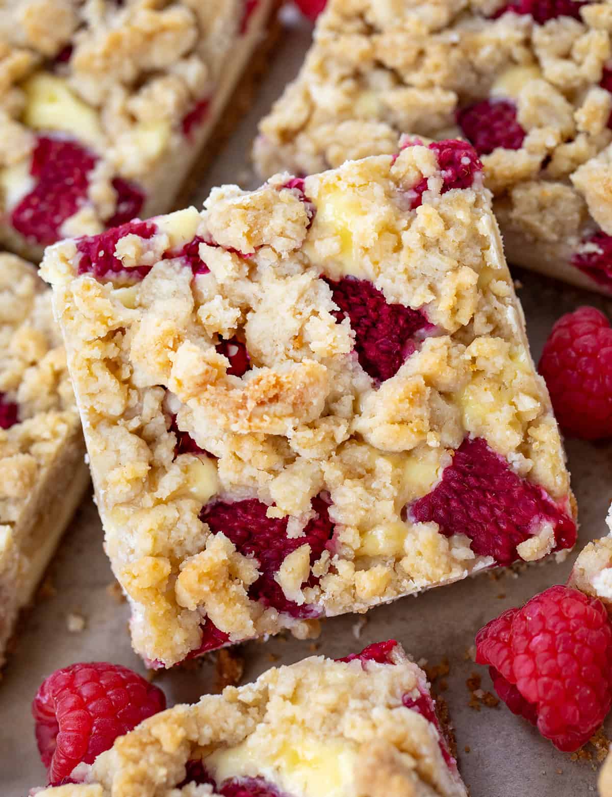 CLose up of Raspberry Cheesecake Bars close together on a table.