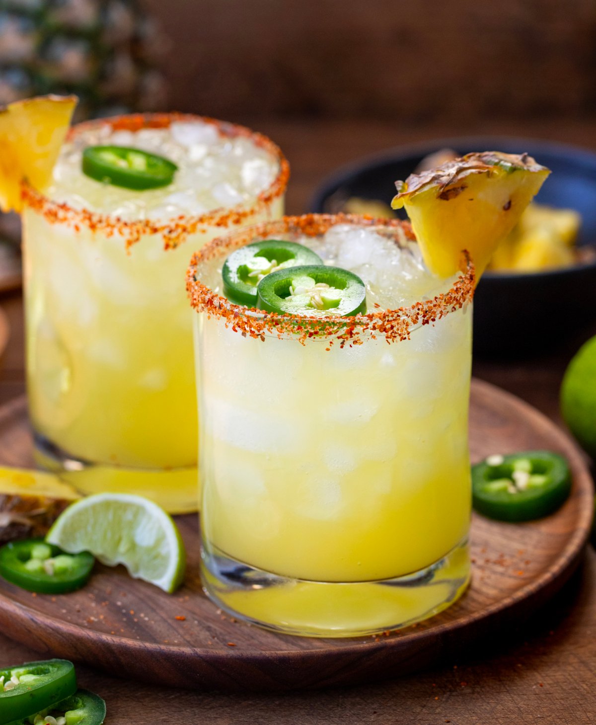 Glasses of Spicy Pineapple Margarita on a wooden table close up.