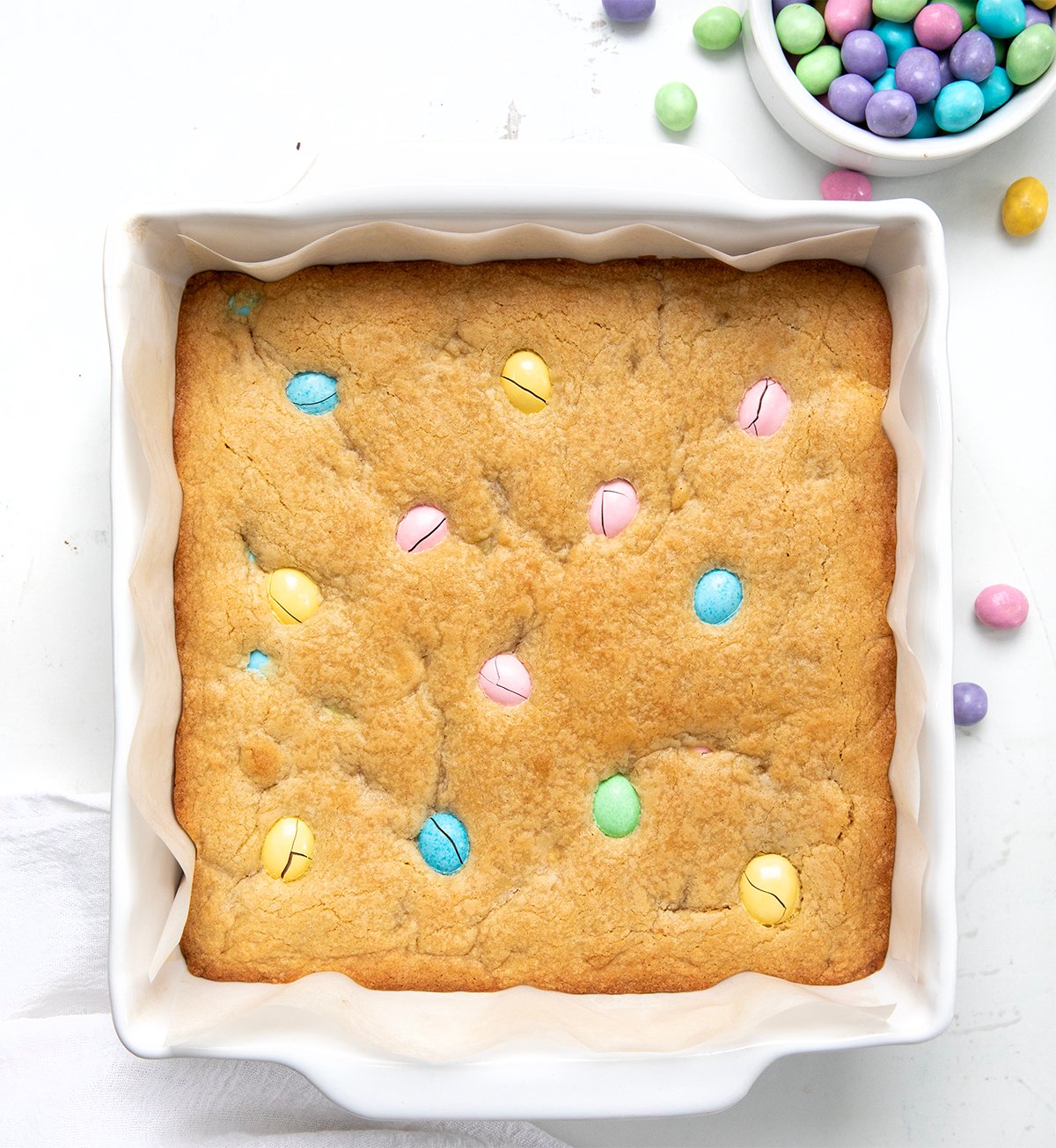 White pan of Easter Blondies on a white table shot from overhead.