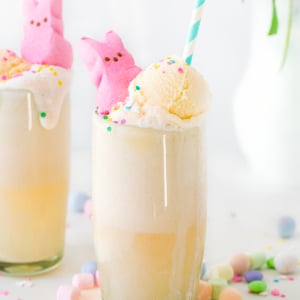 Two Easter Bunny Floats on a white table with easter edible decor and fresh flowers.