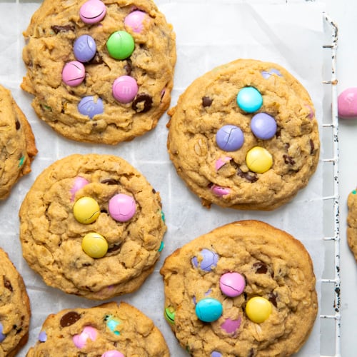 Easter Monster Cookies on a cooling rack on a white counter from overhead.