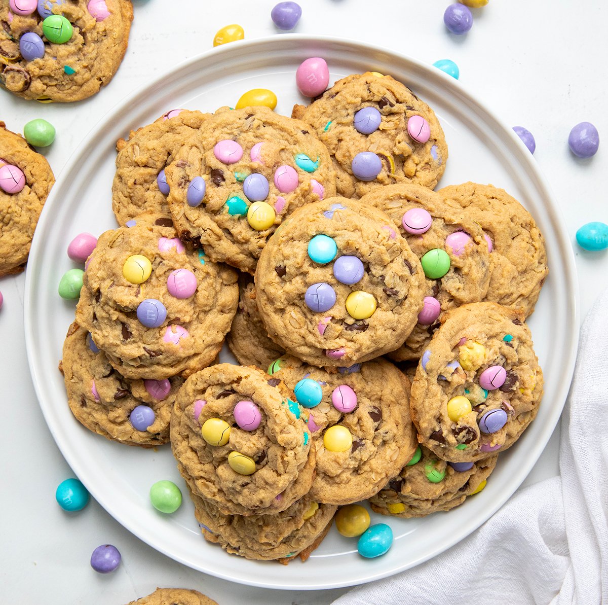 White plate of Easter Monster Cookies on a white table shot from overhead.