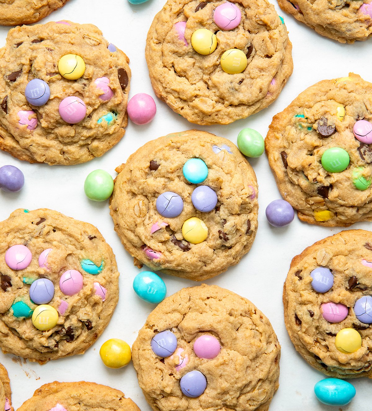 Looking down on Easter Monster Cookies with pastel M&M's on a white table.