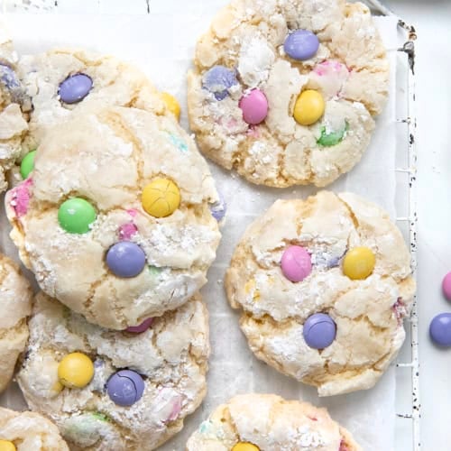 Easter Ooey Gooey Butter Cookies on a cooling rack on a white table with pastel M&M's.