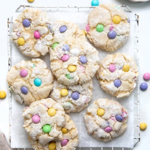 Easter Ooey Gooey Butter Cookies on a cooling rack on a white table with pastel M&M's.