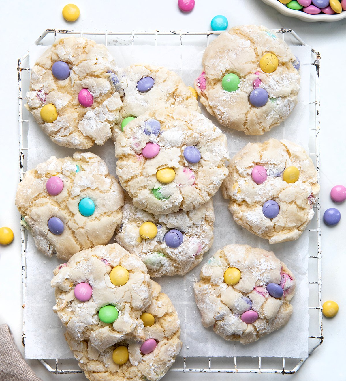 Easter Ooey Gooey Butter Cookies on a cooling rack on a white table with pastel M&M's.