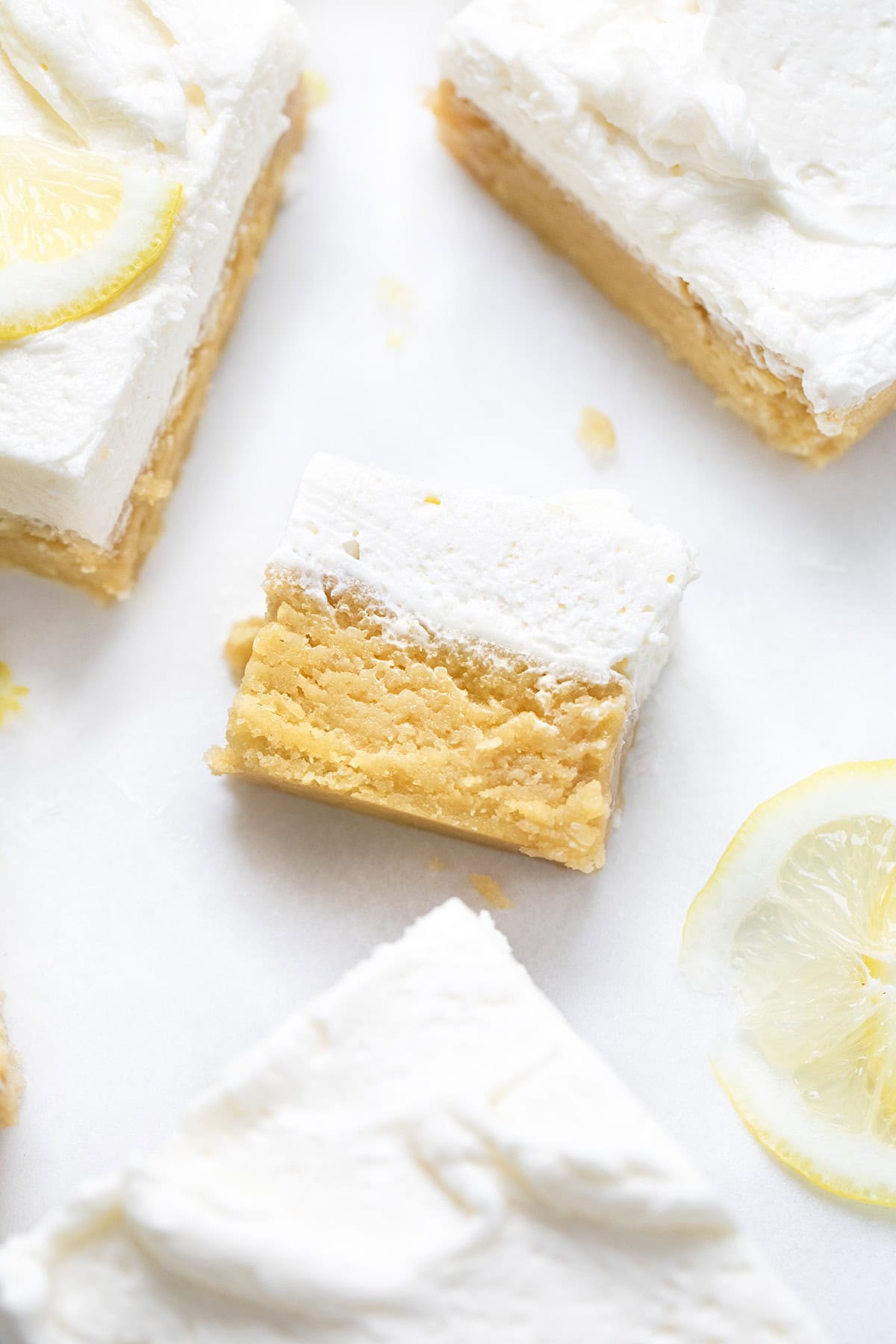 Frosted Lemon Brownie on a white counter on its side showing texture next to other brownies.