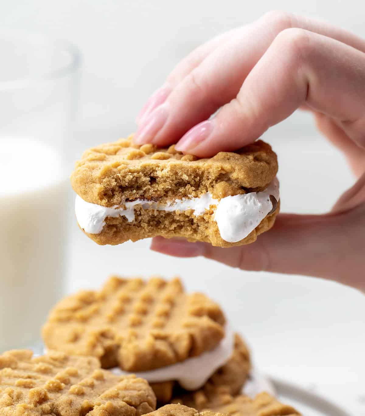 Hand holding a bit into Peanut Butter S'mores Sandwich Cookie.