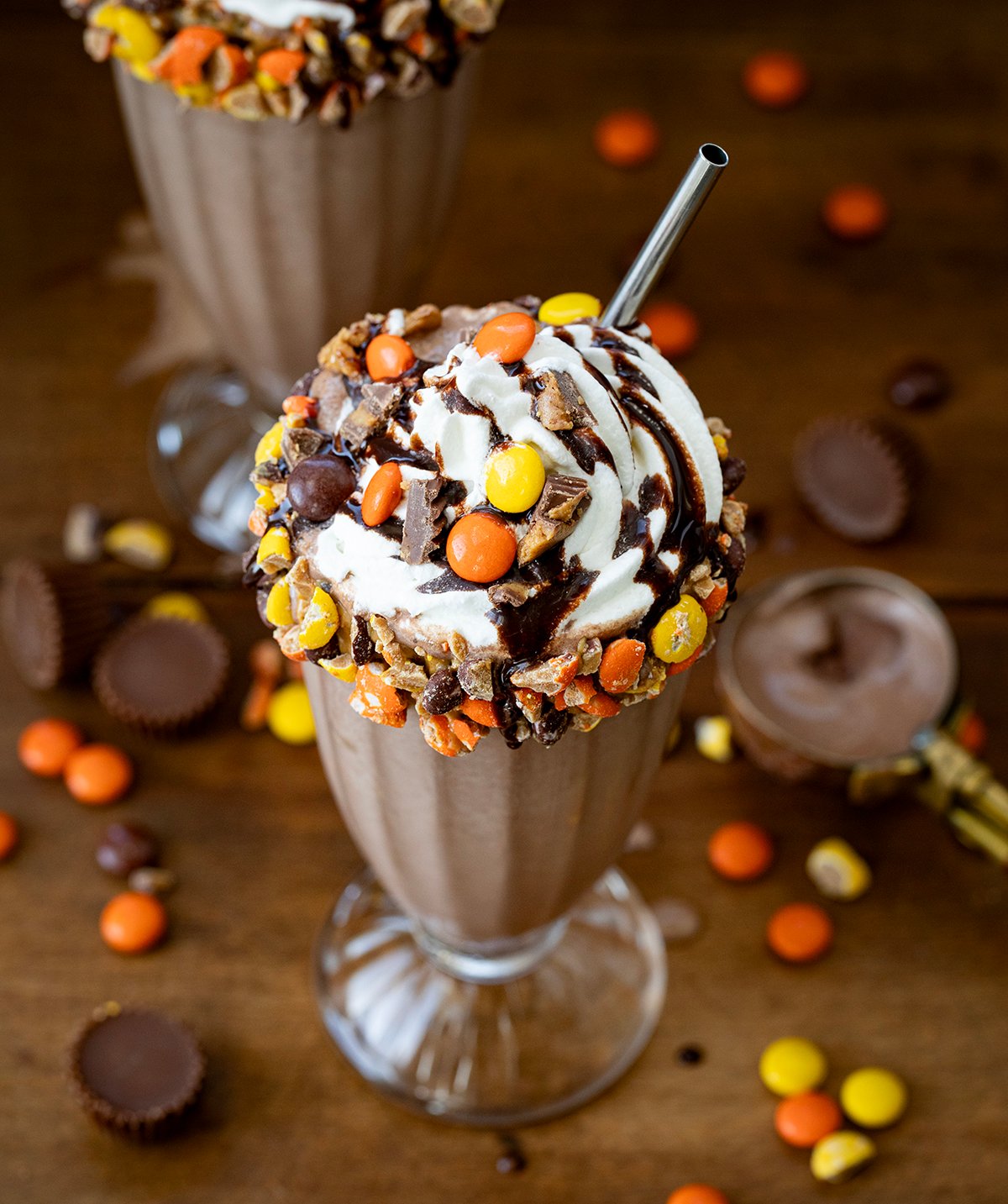 CLose up of the top of Ultimate Peanut Butter Chocolate Milkshake on a wooden table.