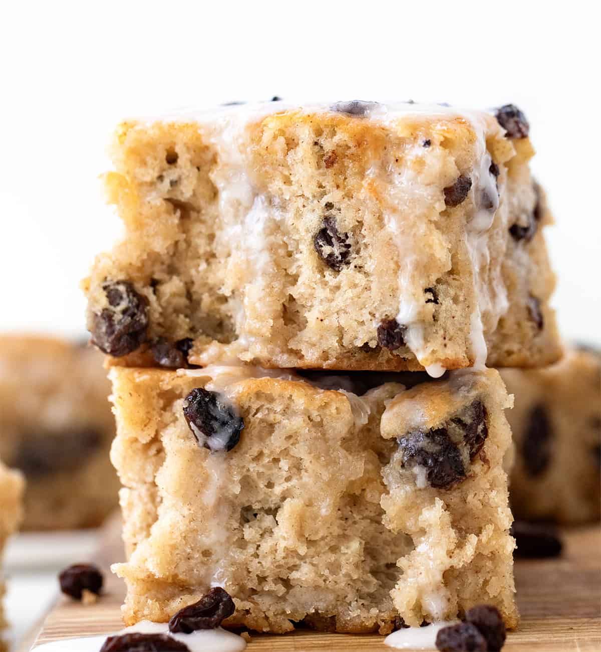 These Cinnamon Raisin Butter Swim Biscuits are a delicious variation of my popular Butter Swim Biscuits, adding the popular flavors of cinnamon and raisins to the mix. Like the original Butter Swim Biscuits, theyโre incredibly soft, fluffy, and filled with rich, buttery goodness, but with an extra layer of texture and sweetness. Cinnamon Raisin Butter Swim Biscuits stacked on a cutting board with glaze drizzling down the sides.