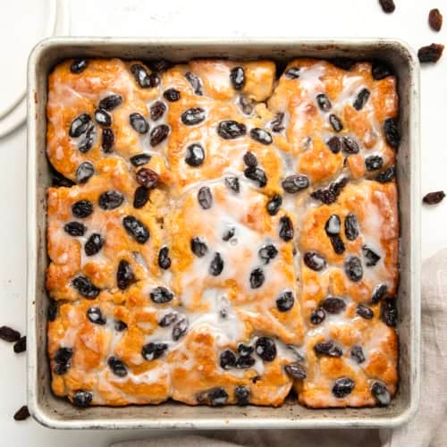Pan of Cinnamon Raisin Butter Swim Biscuits on a white table from overhead.