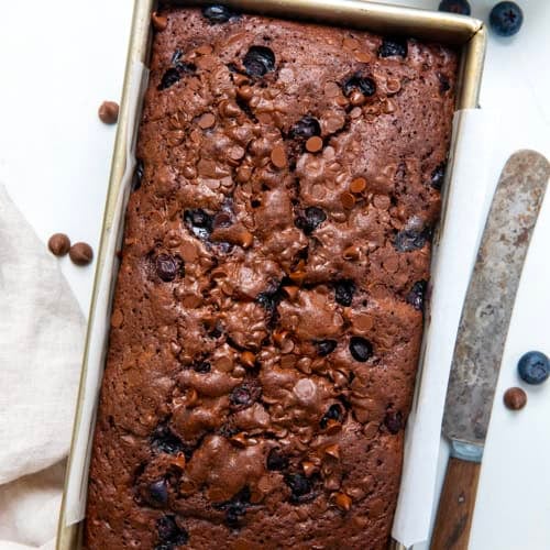 Loaf of Blueberry Brownie Bread on a white table from overhead.