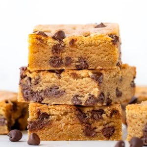 Stack of Browned Butter Chocolate Chip Blondies on a white table.
