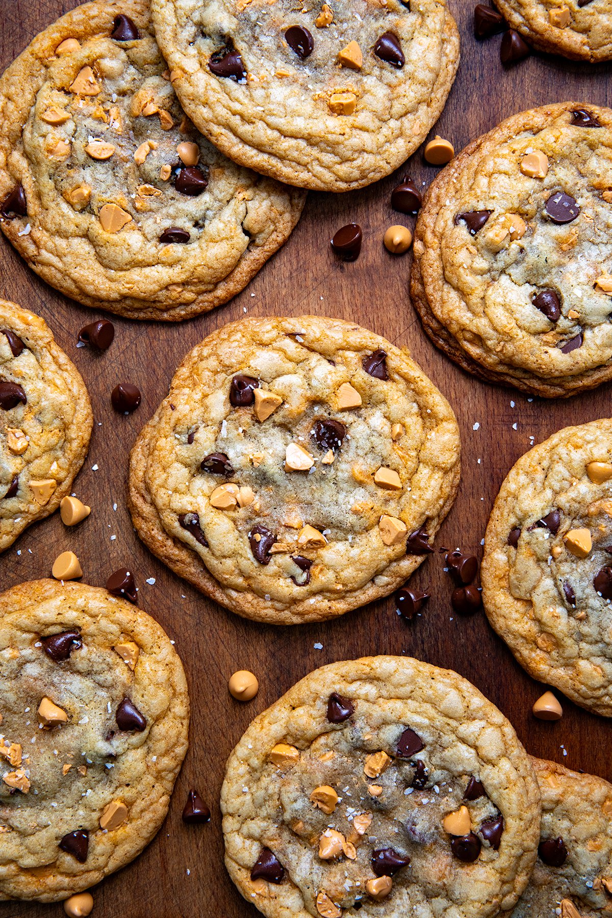 Butterscotch chocolate chip cookies are soft, chewy, and loaded with rich flavor from browned butter, semi-sweet chocolate, and sweet butterscotch chips! Butterscotch Chocolate Chip Cookies on a wooden table shot from overhead.