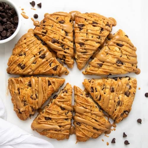 Peanut Butter Chocolate Chip Scones in a circle on a white table rom overhead.