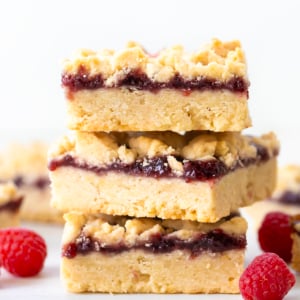 Stack of Raspberry Almond Bars on a white table.