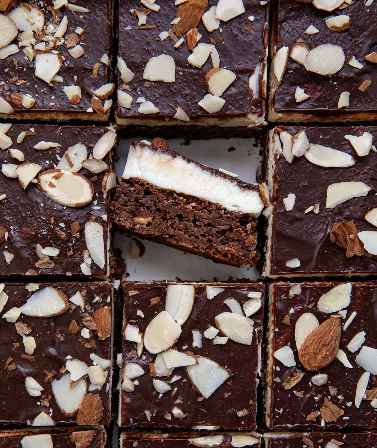Close up of Sherry Almond Brownies with one brownie tiled on its side showing texture.