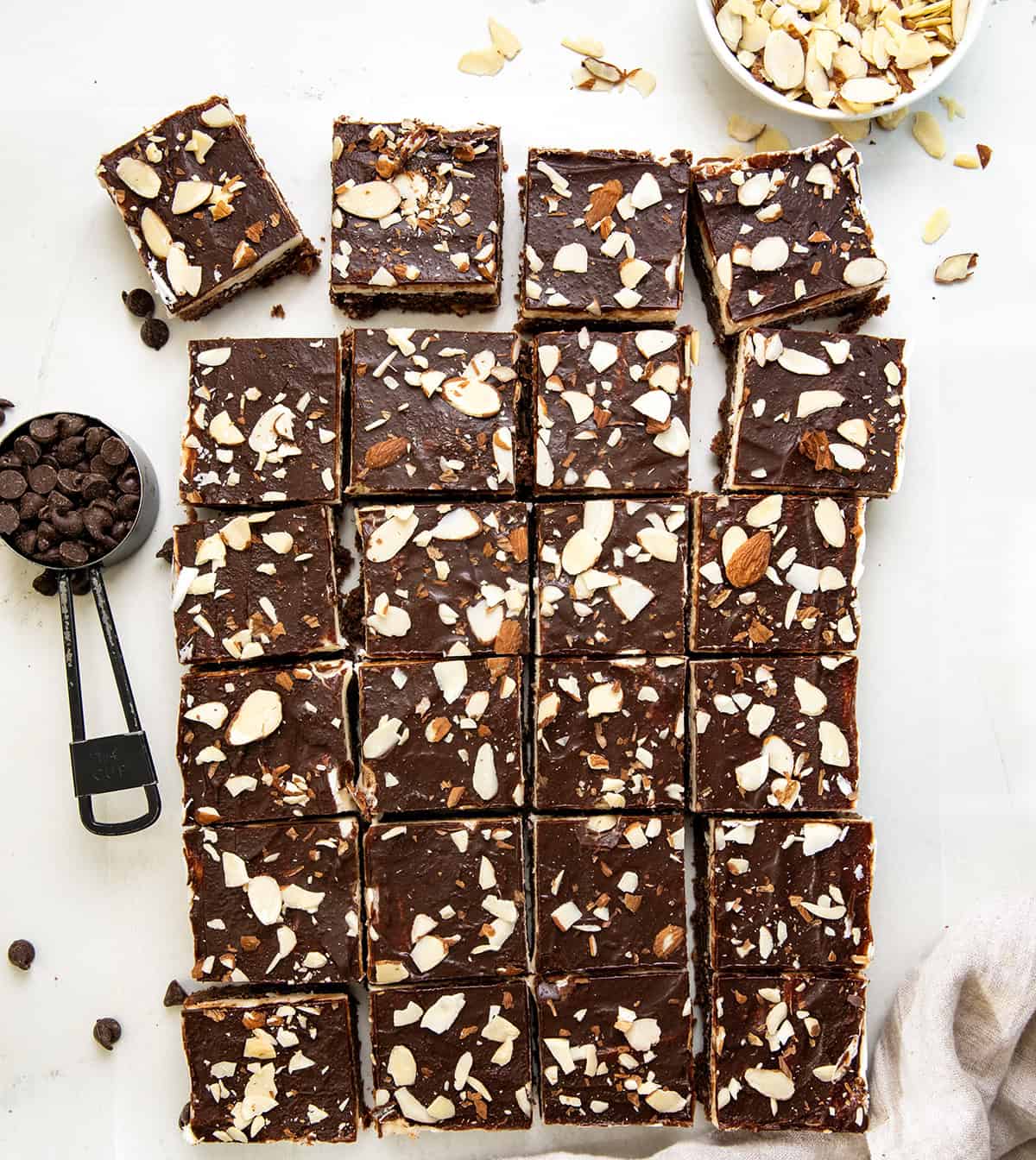 Sherry Almond Brownies on a white table all cut into squares from overhead.