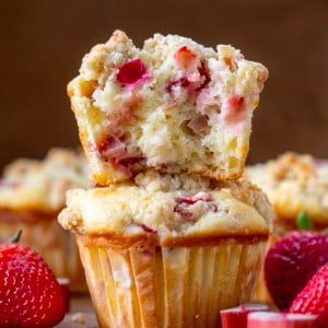 Strawberry Rhubarb Muffins stacked with the top muffin torn in half showing inside texture.