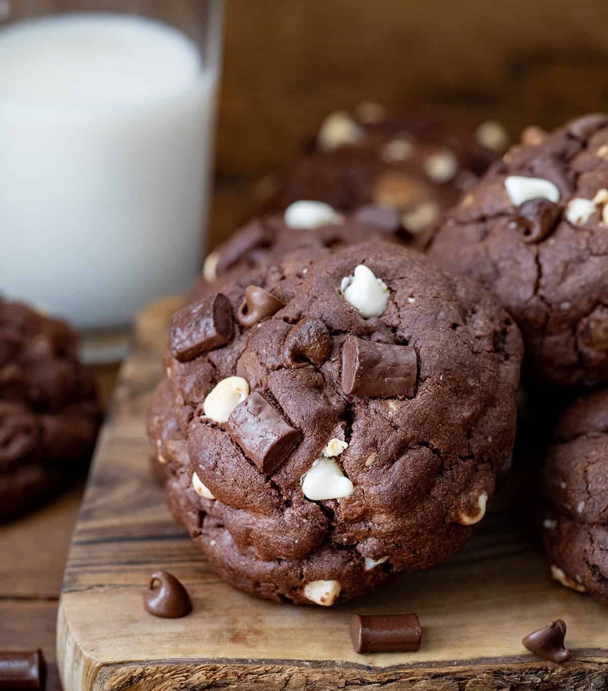 f you love my Ultimate Thick and Chewy Chocolate Chip Cookies, get ready for these Triple Chocolate Chunk Cookies! They are made with three kinds of chocolate (yes, three!), and that ultra-thick, soft-based texture you already know and love! Close up of Triple Chocolate Chunk Cookies with a glass of milk in the background.