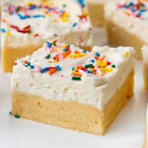 Close up of a Birthday Sugar Cookie Bar on a white table surrounded by other bars.