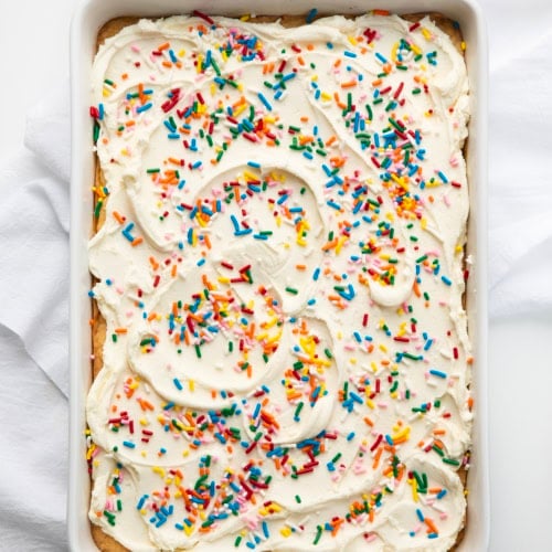 Pan of Birthday Sugar Cookie Bars on a white table from overhead.
