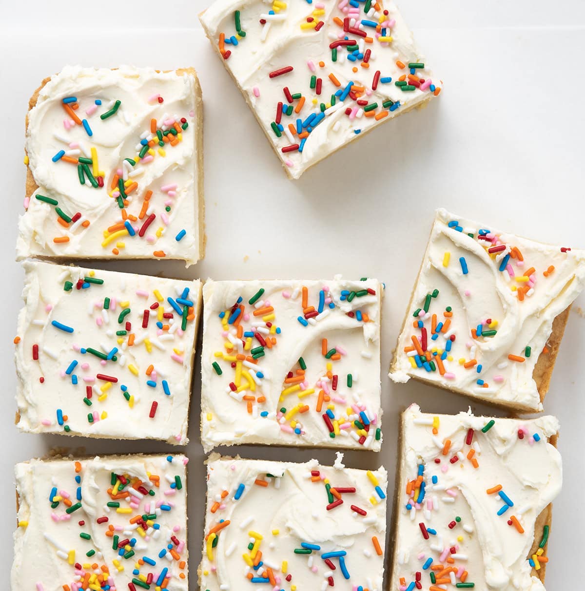 Birthday Sugar Cookie Bars cut into squares with some tilted and askew.