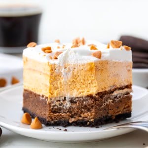 Piece of Butterscotch Mud Bars on a white plate with a bite removed.