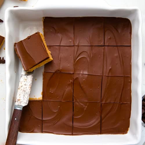 Pan of Lunch Lady Peanut Butter Bars with a couple of bars removed and one resting.