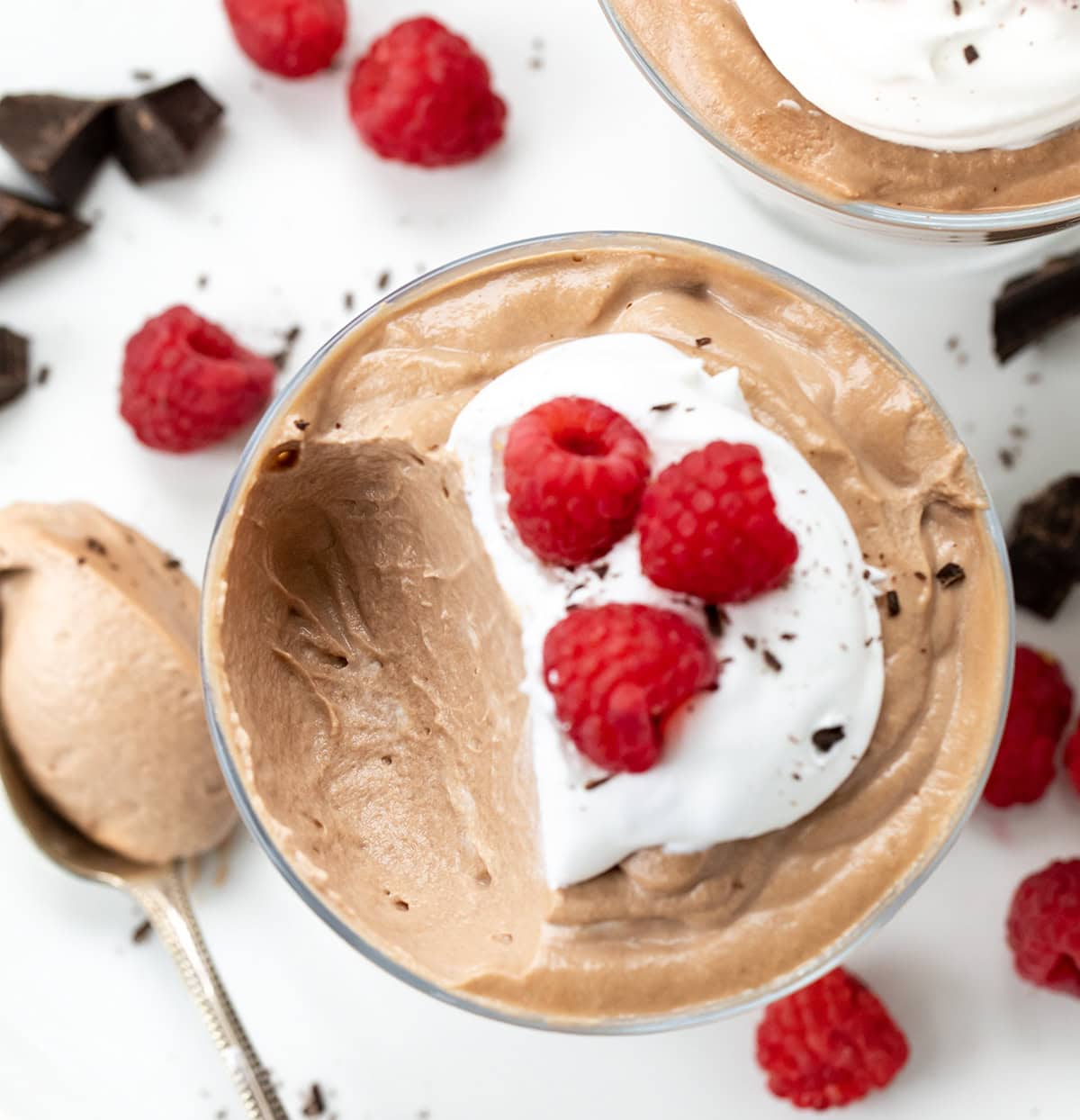 This Two-Ingredient Nutella Mousse is as easy as it gets, and so delicious, you'd never guess it only takes minutes to make! No baking, no eggs, no fuss, just a creamy, dreamy no-bake dessert that feels a little fancy without any extra work. It’s perfect for a quick treat or an easy make-ahead dessert for guests. I like to top mine with a dollop of whipped cream, or even a drizzle of Nutella! Glass of Nutella Mousse with a portion removed showing creamy texture inside.