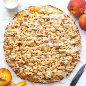 Whole Peach Cobbler Pizza on a white table from overhead.