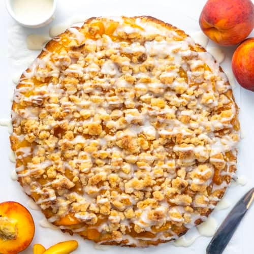 Whole Peach Cobbler Pizza on a white table from overhead.