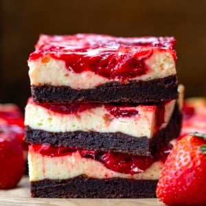 Stack of Strawberry Cheesecake Brownies on a wooden table close up.