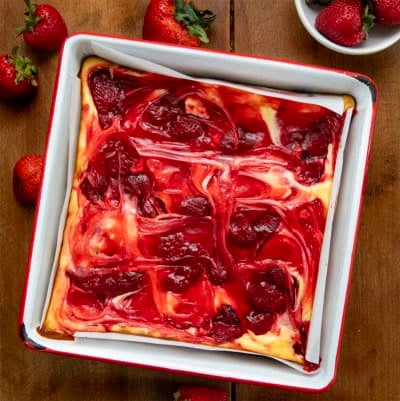 Strawberry Cheesecake Brownies in a white pan on a wooden table from overhead.