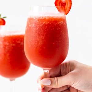 Hand holding a glass of Strawberry Frose.