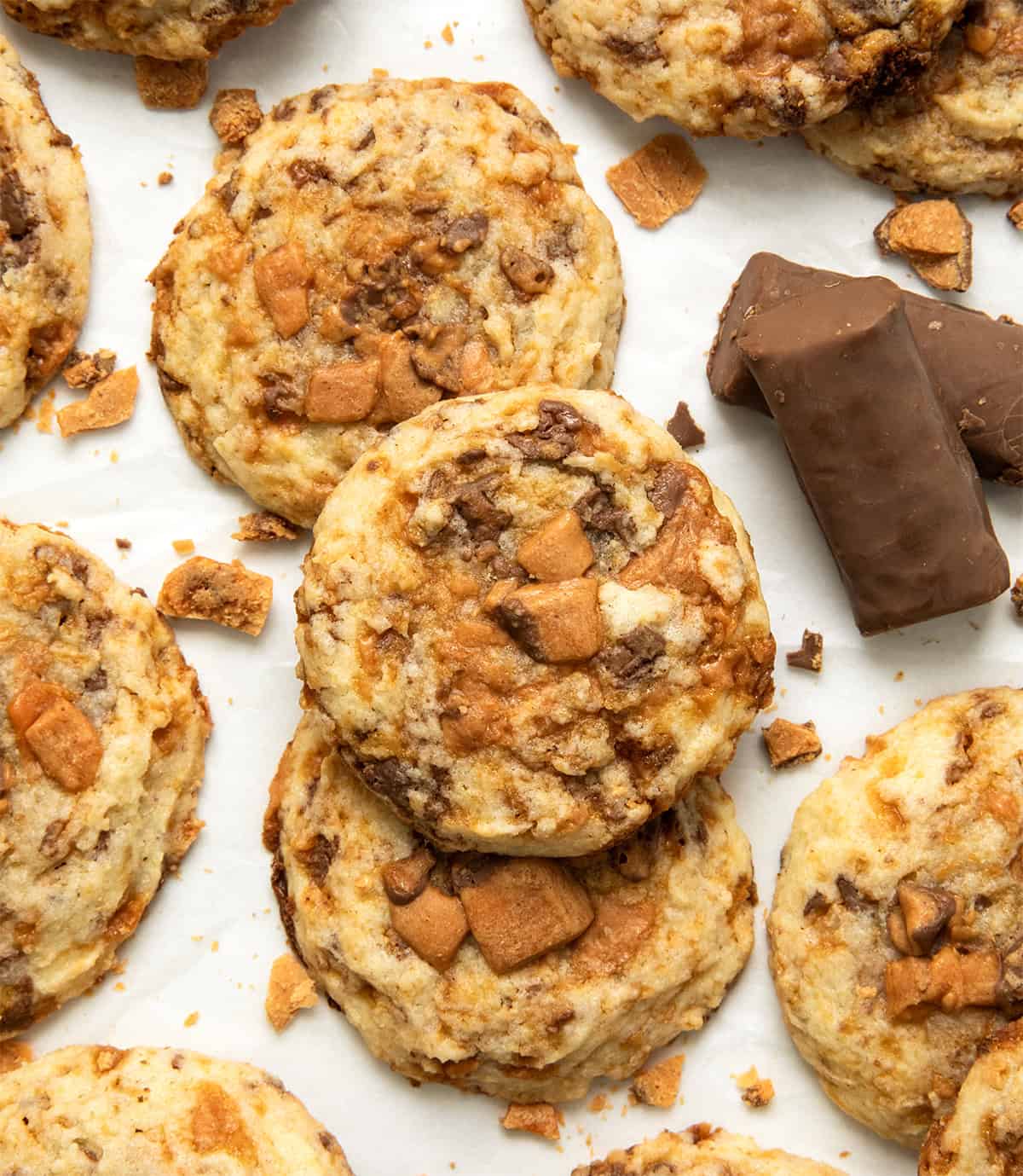 Butterfinger Cookies on a white table with small butterfinger bars from overhead.
