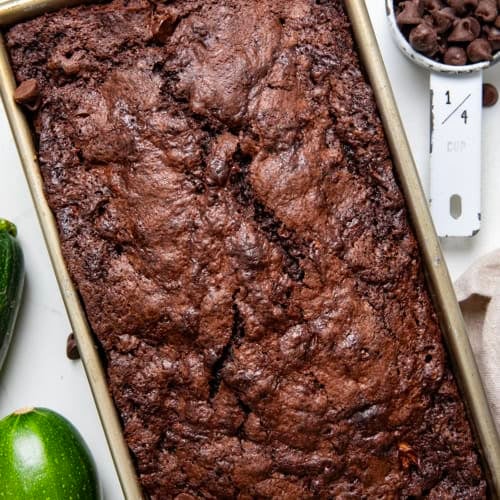 Loaf of Chocolate Zucchini Bread in the pan on a wooden table from overhead.