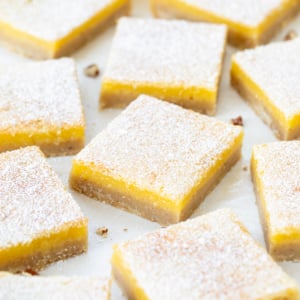 Lemon Bars with Pecan Crust cut into squares on a white table close up.