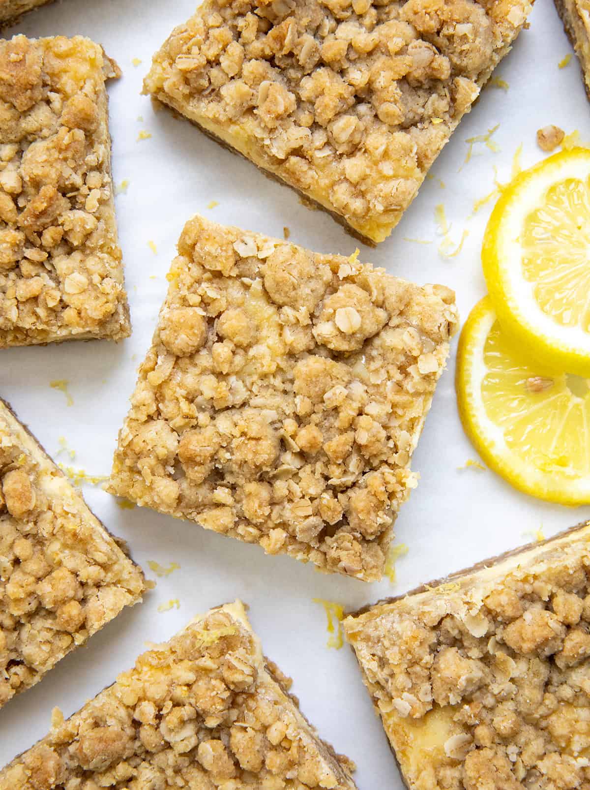 If you love my Lemon Crumb Bars, youโre going to love this fun variation! These Lemonade Crumb Bars use frozen lemonade concentrate for an extra punch of bright, tangy flavor. Theyโre simple to make, with a creamy lemon filling and a soft, crumbly oat crust and topping. Great for summer or anytime youโre craving something sweet and citrusy. Cut up Lemonade Crumb Bars on a white table from overhead.