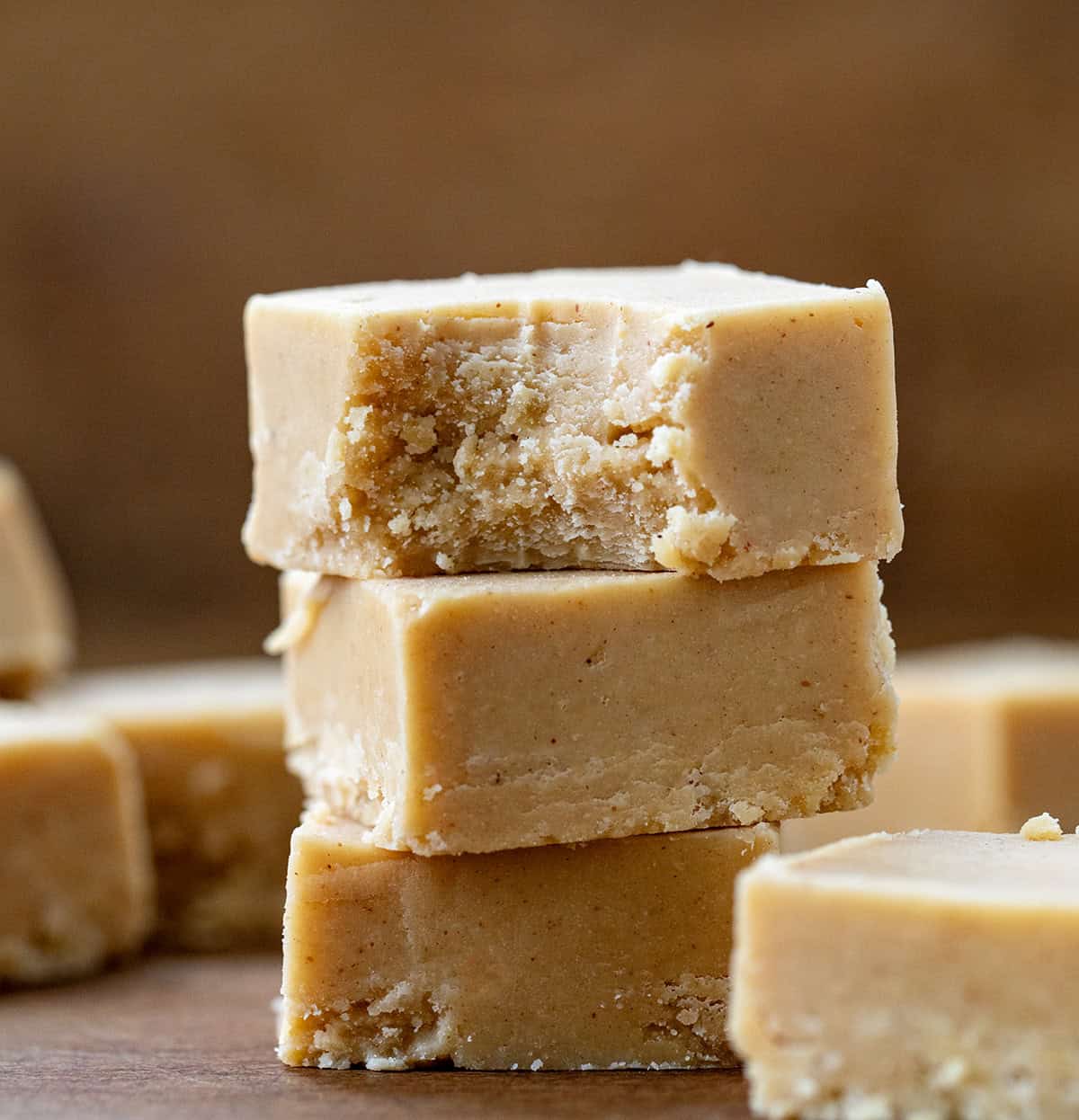 This Microwave Peanut Butter Fudge is rich, creamy, and made with just three simple ingredients. It has a smooth, melt-in-your-mouth texture and the perfect sweet-and-salty peanut butter flavor. No stovetop, no candy thermometer--just a microwave and a little chill time! Stack of Microwave Peanut Butter Fudge with the top piece having a bite taken out of it.