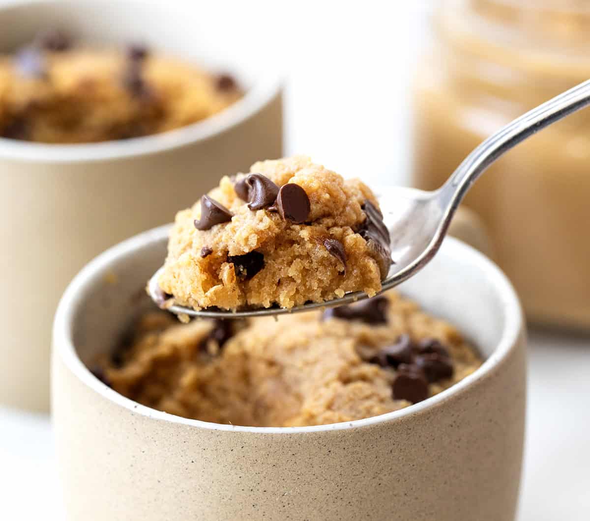 This microwave Peanut Butter Mug Cake is rich, gooey, and ready in just minutes, no oven needed! It's a quick and satisfying single-serve dessert for peanut butter lovers. I love that I can satisfy a sweet craving without baking a whole cake! Spoonful of Peanut Butter Mug Cake held above the mug.