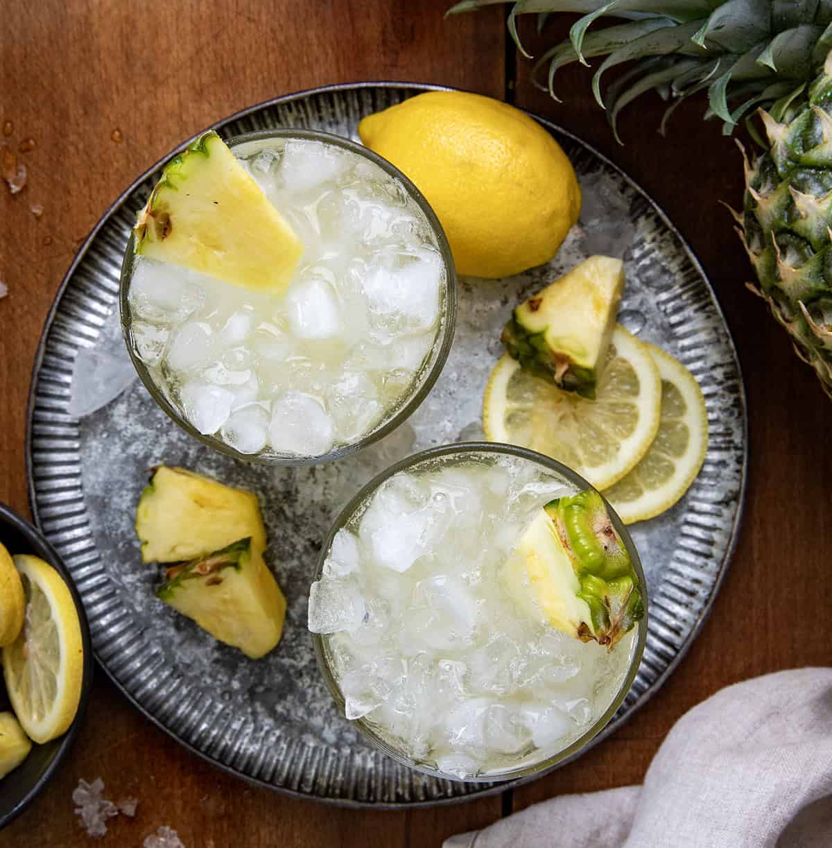 Two glasses of Pineapple Bourbon Fizz on a metal tray from overhead.