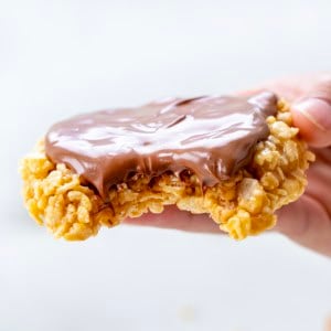 Hand holding Single-Serving Scotcheroo with a big bite taken out of it.
